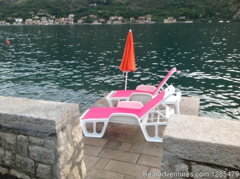 Sunbathing chairs on swimming area.